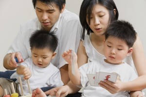 Family spending time together, both parent accompanying their sons playing and learning