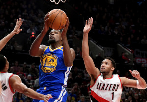 Golden State Warriors forward Kevin Durant drives to the basket past Portland Trail Blazers guard Evan Turner during the first half of an NBA basketball game in Portland, Ore., Sunday, Jan. 29, 2017. (AP Photo/Steve Dykes)