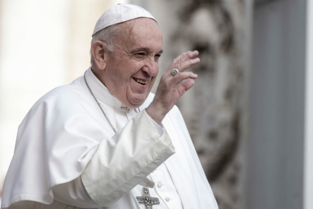 Pope Francis smiling with hand raised