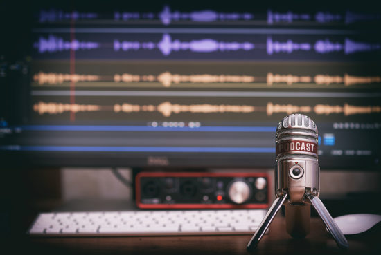 A photo of a microphone with sound files in the background