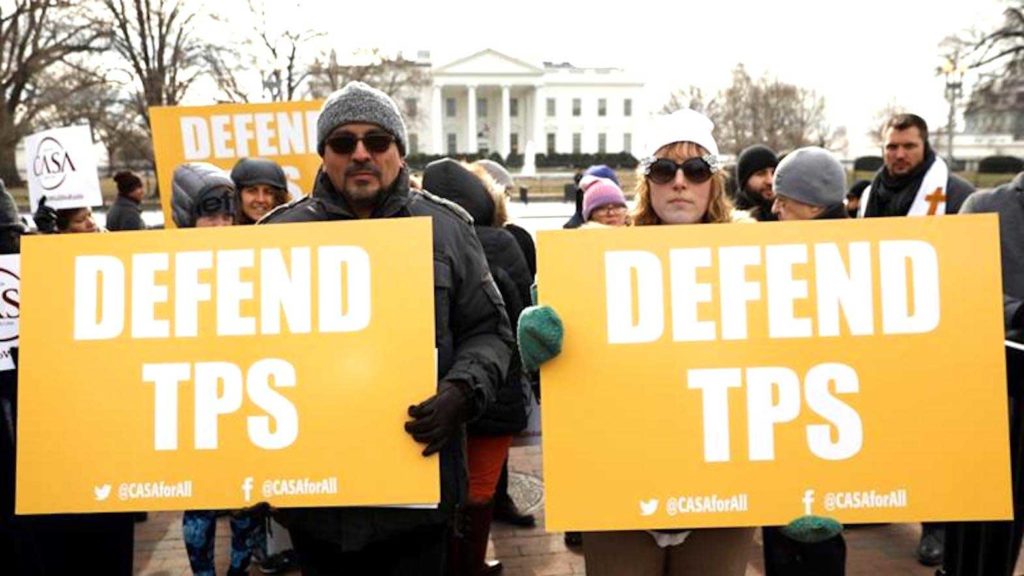 Demonstrators hold signs protesting the termination of Salvadorans' Temporary Protected Status (TPS) in front of the White House in Washington, DC in 2018 [Kevin Lamarque/Reuters]