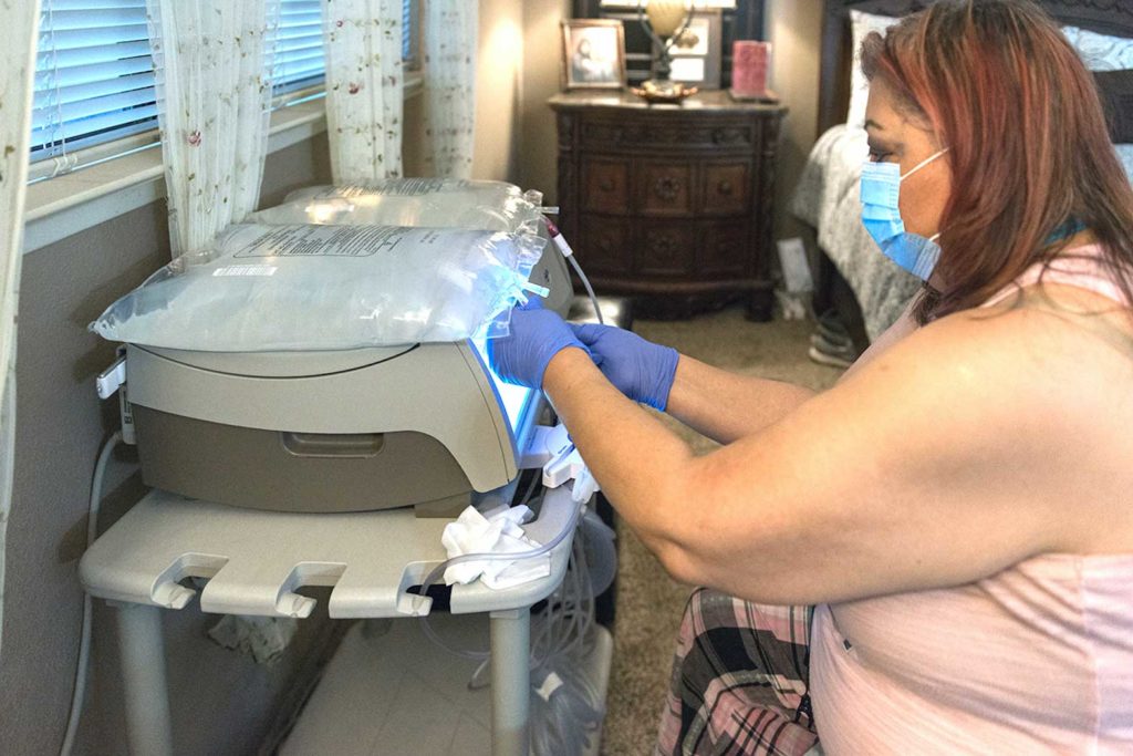 Duenas vigorously washes her hands before she cleans the area around the catheter in her abdomen. She also sterilizes the dialysis equipment before hooking herself up for the night.(Heidi de Marco/California Healthline)