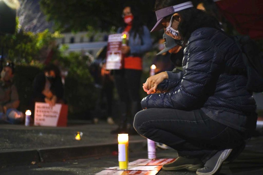 Vigil attendees kneel and hold hands as the names of health care workers that have died from COVID-19 are recited.Karen Rothblatt, Alameda nurse, speaks during the vigil. INQUIRER/Miguel Carrion