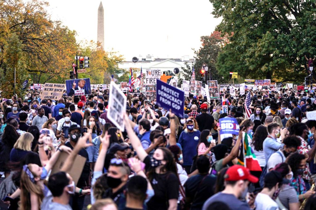 People celebrating Joe Biden’s victory in Black Lives Matter Plaza in Washington, DC [Joshua Roberts/Reuters]