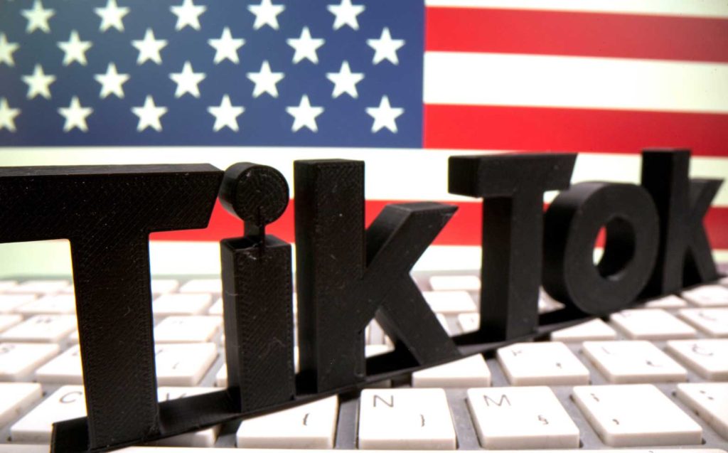 A 3D printed TikTok logo is placed on a keyboard in front of U.S. flag in this illustration taken October 6, 2020. REUTERS/Dado Ruvic/Illustration/File Photo