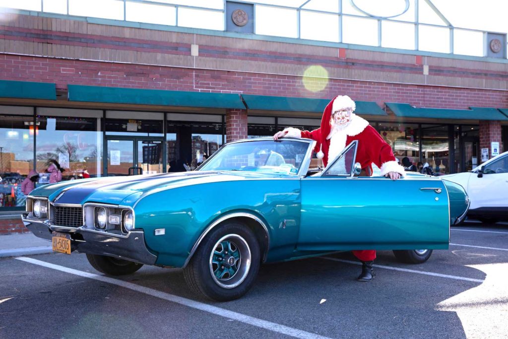  Dana Friedman, a trial lawyer who has spent 6 months of each year growing out his beard for his annual appearance as Santa Claus since 2001, stands for a portrait outside with children wearing masks as a precautionary measure at the Bay Terrace Shopping Center in Queens as the global outbreak of the coronavirus disease (COVID-19) continues, in New York City, U.S., December 6, 2020. REUTERS/Caitlin Ochs