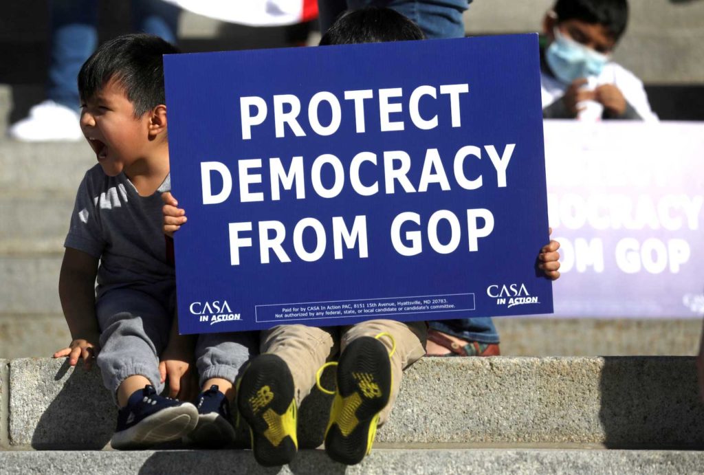 Young supporters of Democratic candidate Joe Biden sit on the steps as supporters of U.S. President Donald Trump rally nearby outside of the State Capitol building after news media declared Joe Biden to be the winner of the 2020 U.S. presidential election, in Harrisburg, Pennsylvania, U.S., November 7, 2020. REUTERS/Leah Millis/File Photo