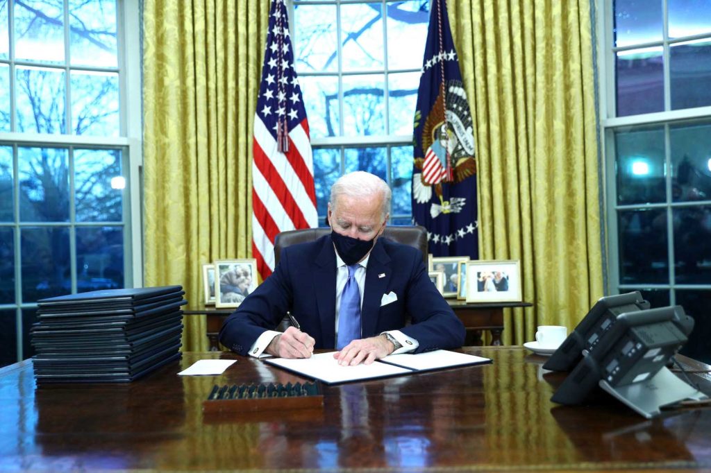U.S. President Joe Biden signs executive orders in the Oval Office of the White House in Washington, after his inauguration as the 46th President of the United States, U.S., January 20, 2021. REUTERS/Tom Brenner/File Photo