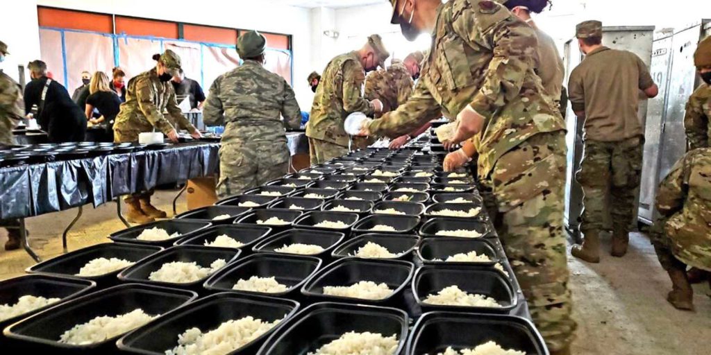  National Guard troops and volunteers preparing to serve meals. FACEBOOK
