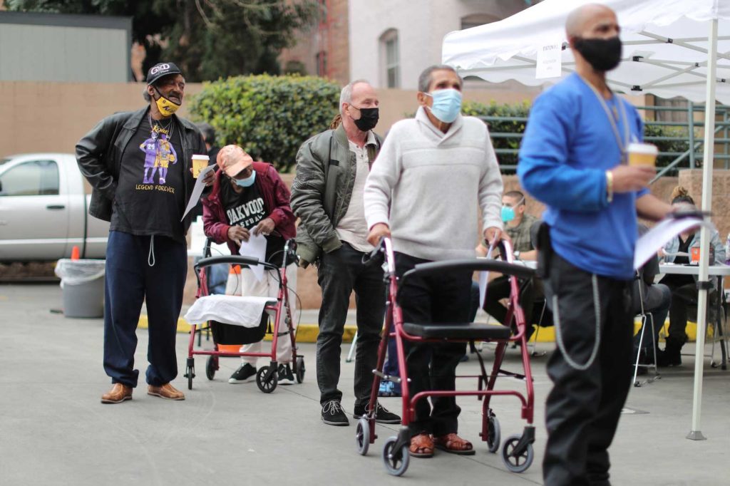 People queue to receive coronavirus disease (COVID-19) vaccinations at the LA Mission homeless shelter on Skid Row, in Los Angeles, California, U.S., February 10, 2021. REUTERS/Lucy Nicholson