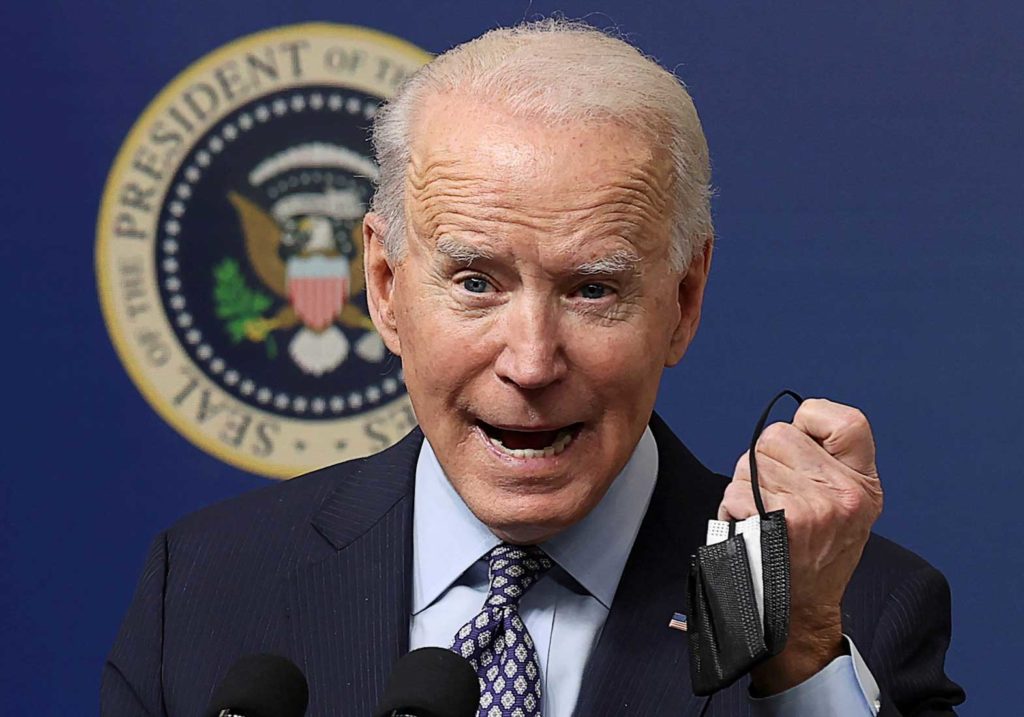 U.S. President Joe Biden displays his face mask as he speaks during an event to commemorate the 50 millionth coronavirus disease (COVID-19) vaccination in the South Court Auditorium at the White House in Washington, U.S., February 25, 2021. REUTERS/Jonathan Ernst