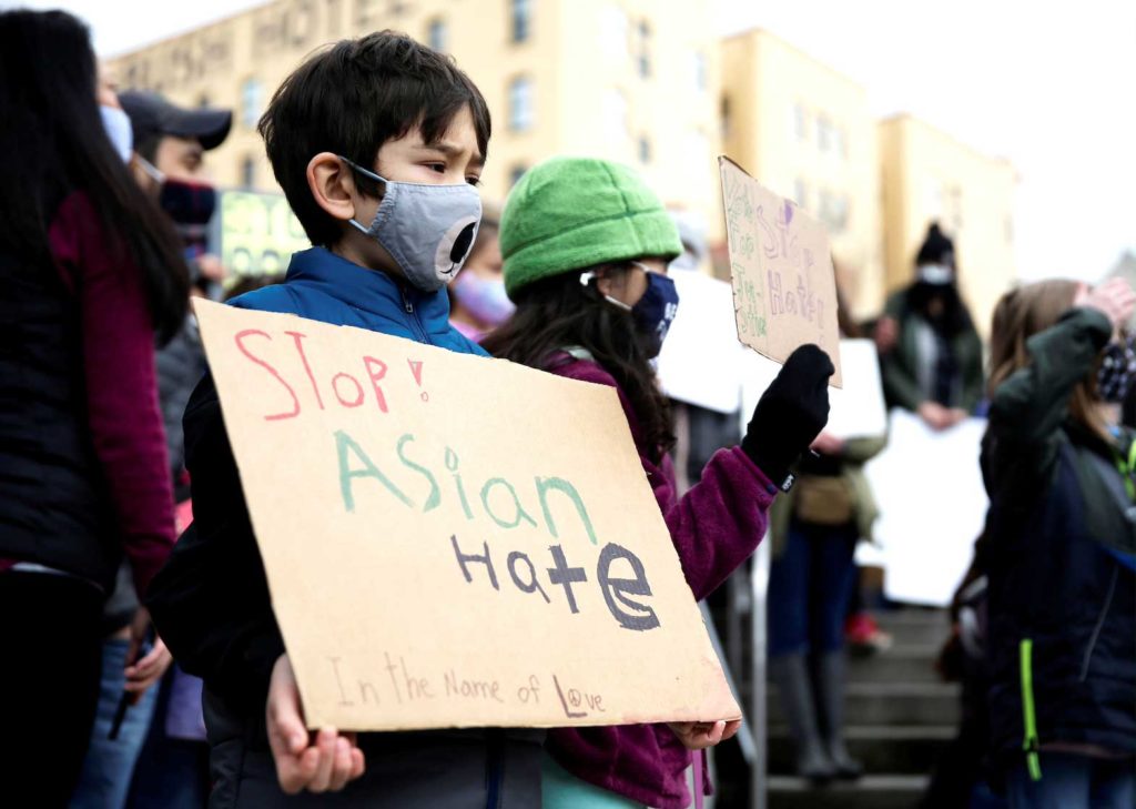 Zander Peterson, 8 and Aria Mingus-Shah, 8, hold signs during a "Kids vs. Racism" rally against anti-Asian hate crimes at Hing Hay Park in the Chinatown-International District of Seattle, Washington, U.S. March 20, 2021. REUTERS/Lindsey Wasson