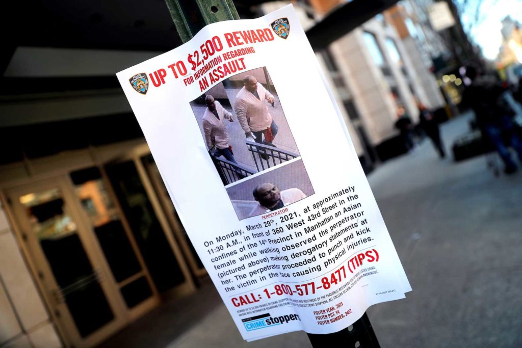 A New York City Police Department (NYPD) wanted poster of the alleged perpetrator in an assault attack on an Asian woman on March 29, 2021, is pictured outside an apartment building on Manhattan's West 43rd Street in New York City, New York, U.S., March 30, 2021. REUTERS/Mike Segar