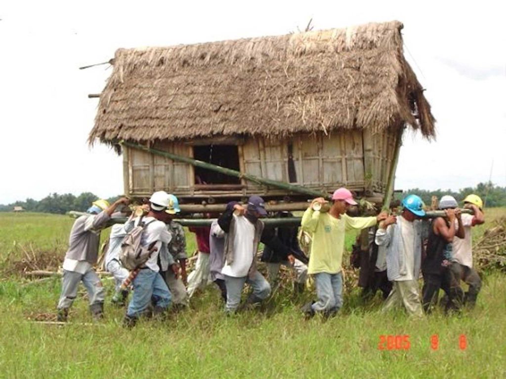 Villagers moving a house. PINTEREST