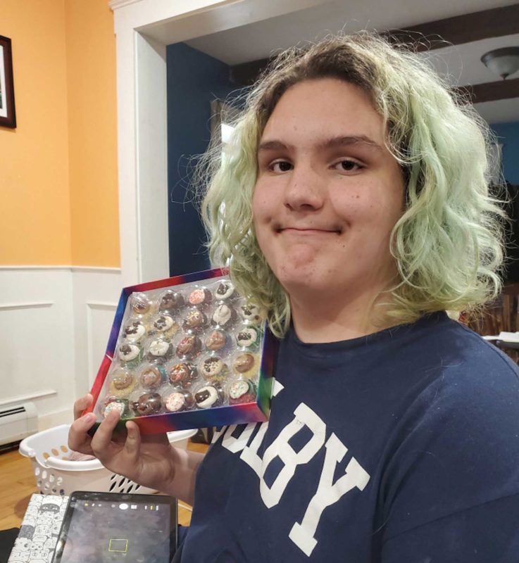 Lucien Wiggins, 12, poses with a tray of mini-cupcakes sent by a relative after he left Tufts Children’s Hospital on June 9. Wiggins suffered myocarditis following a Covid vaccination but says it was worth it to avoid getting Covid.(BETH CLARKE)