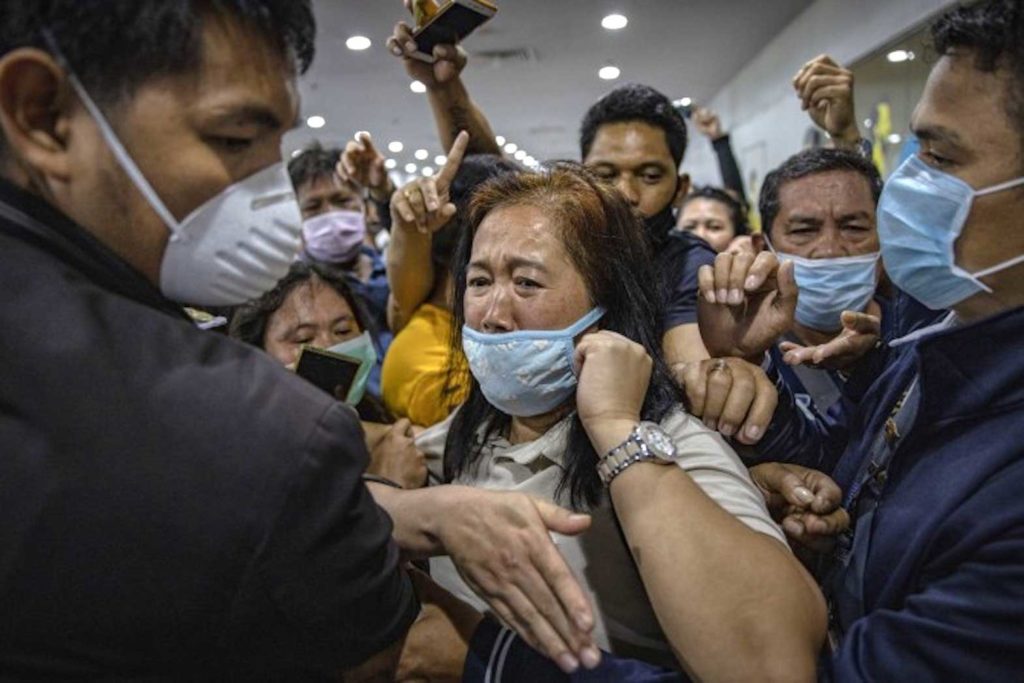 (Acayan's nominated photo) Airport security staff attempt to control the crowd as Filipinos hoping to get on flights out of Manila hours before it is placed on lockdown queue at Ninoy Aquino International Airport on March 14, 2020. EZRA ACAYAN