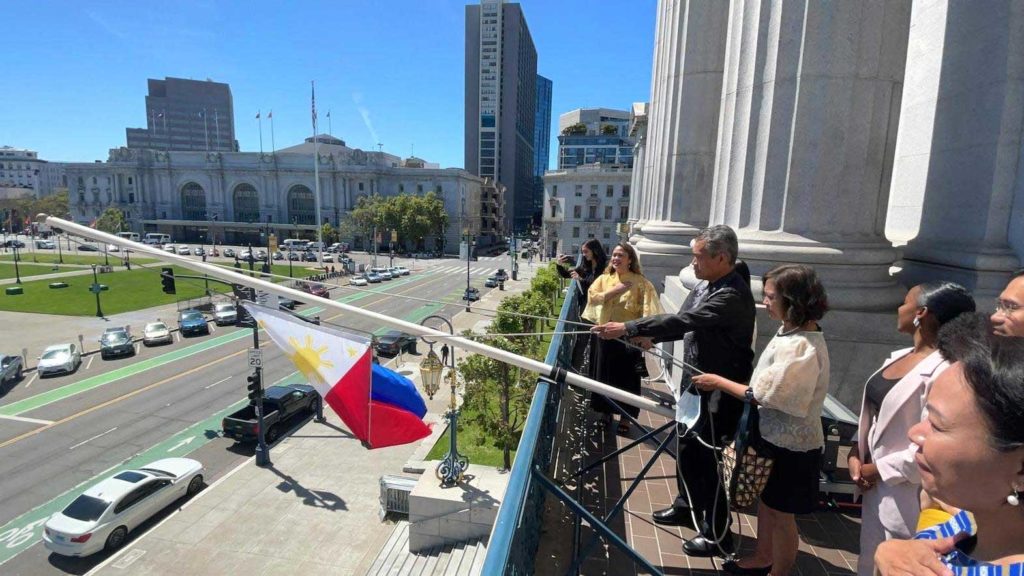 ConGen Neil Ferrer (in black barong) is assisted by San Francisco City Mayor London Breed’s Protocol Officer Meron Foster (to Ferrer’s left) in the flag-raising ceremony in the balcony of the San Francisco City Hall of the Philippine flag witnessed by Consulate officials. CONTRIBUTED