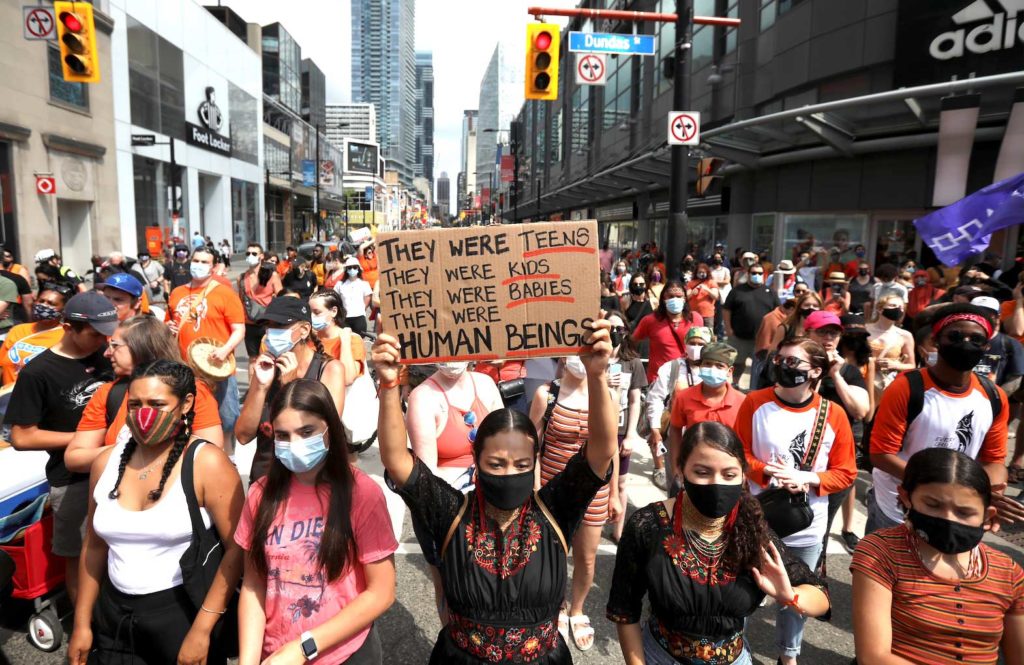 People take part in a march after the discovery of hundreds of remains of children at former indigenous residential schools, on Canada Day in Toronto, Ontario, Canada July 1, 2021. REUTERS/Carlos Osorio