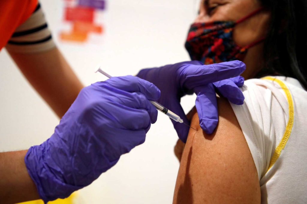 A medical worker administers a dose of the "Comirnaty" Pfizer-BioNTech COVID-19 vaccine to a patient at a coronavirus disease (COVID-19) vaccination center installated in front of Paris town hall, France, July 7, 2021. REUTERS/Sarah Meyssonnier