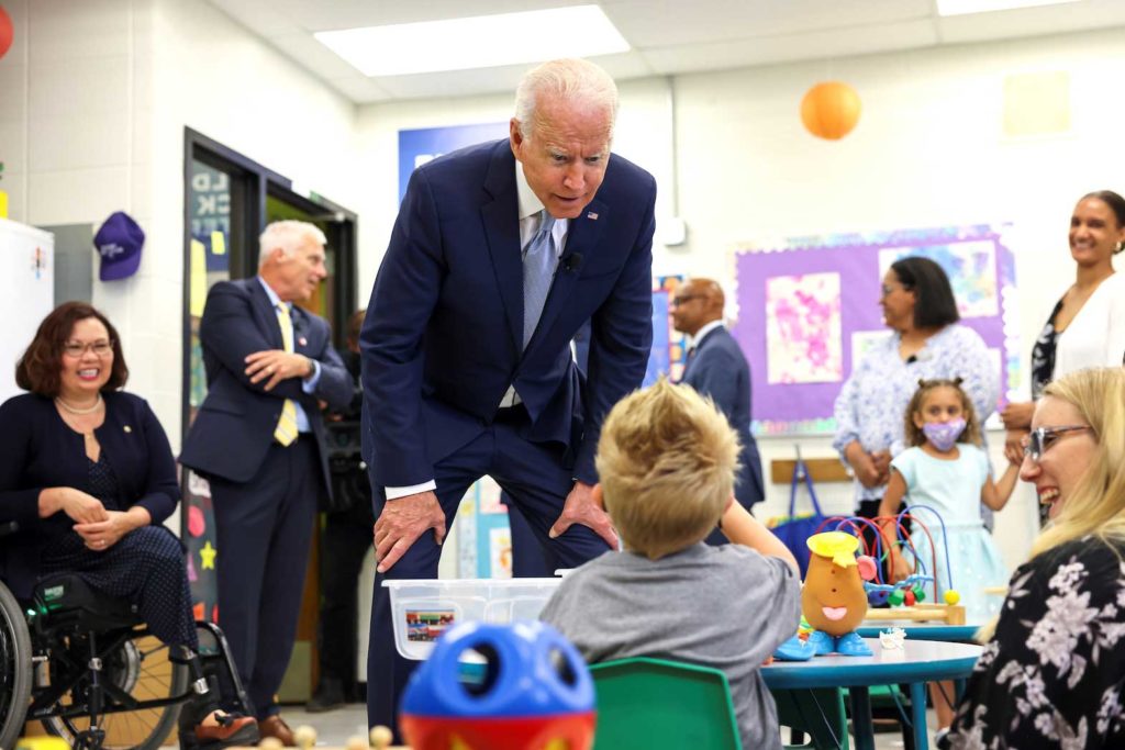 U.S. President Joe Biden flanked by President of McHenry County College Clint Gabbard and Senator Tammy Duckworth, speaks with a child, as he tours the Children's Learning Center at McHenry County College during a visit to the northwest Chicago suburb Crystal Lake, Illinois, U.S., July 7, 2021. REUTERS/Evelyn Hockstein/File Photo