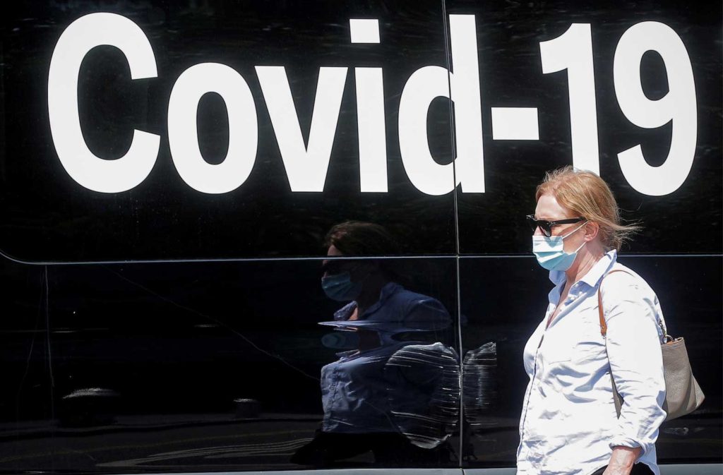 A woman wearing a mask passes by a coronavirus disease mobile testing van, as cases of the infectious Delta variant of COVID-19 continue to rise, in Washington Square Park in New York City, U.S., July 22, 2021. REUTERS/Brendan McDermid