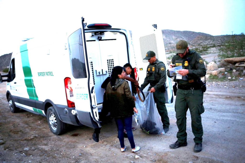 Migrants from Central America who were detained hand over their belongings to U.S. Border Patrol agents after crossing into the United States from Mexico, in Sunland Park, New Mexico, U.S., July 22, 2021. REUTERS/Jose Luis Gonzalez/File Photo