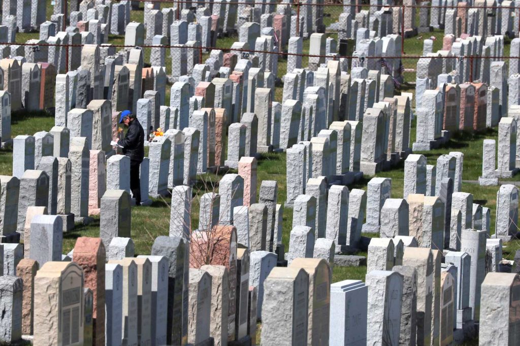  A person walks among the grave markers in a cemetery amid the coronavirus disease (COVID-19) outbreak in Everett, Massachusetts, U.S., April 7, 2020. REUTERS/Brian Snyder