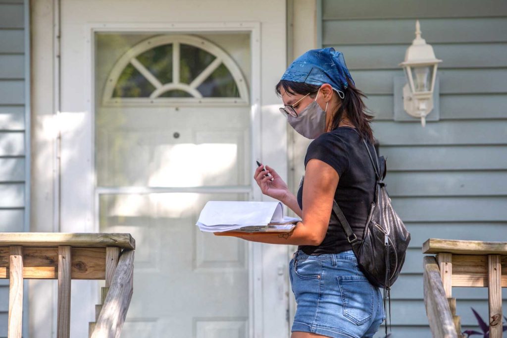 Denver Foote, canvasser with Iowa Citizens for Community Improvement, CCI, makes notes as she knocks on doors to register people to vote in upcoming local elections in Des Moines, Iowa, U.S., August 23, 2021. REUTERS/Rachel Mummey