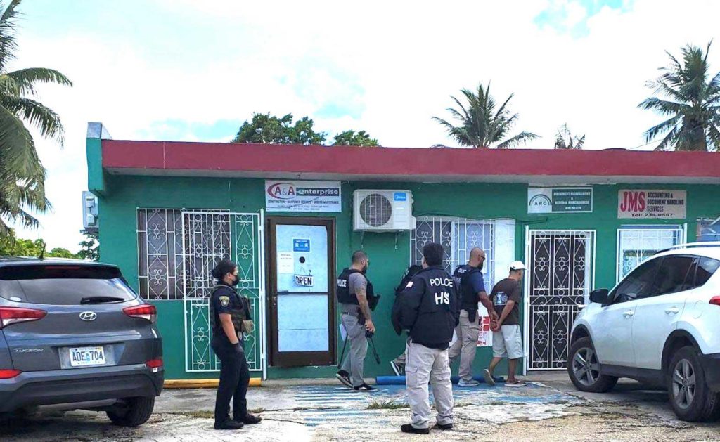 A man is seen in handcuffs as federal agents execute an arrest warrant at a manpower agency in Gualo Rai, Saipan, on Friday morning. Contributed photo  