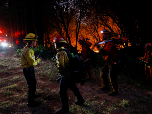 Thousands evacuate rapidly spreading California wildfire as homes burn