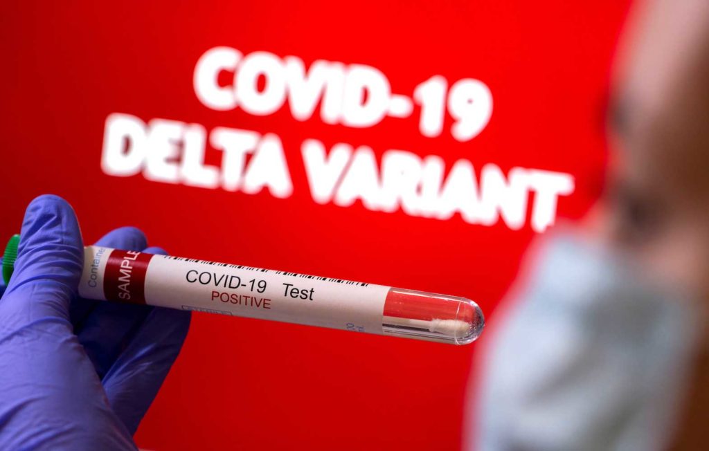 A person holds a test tube labelled 'COVID-19 Test Positive' in front of displayed words 'COVID-19 Delta variant' in this illustration taken August 31, 2021. REUTERS/Dado Ruvic/Illustration