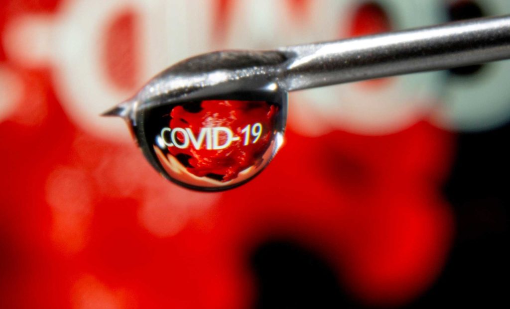  The word "COVID-19" is reflected in a drop on a syringe needle in this illustration taken November 9, 2020. REUTERS/Dado Ruvic/Illustration/File Photo