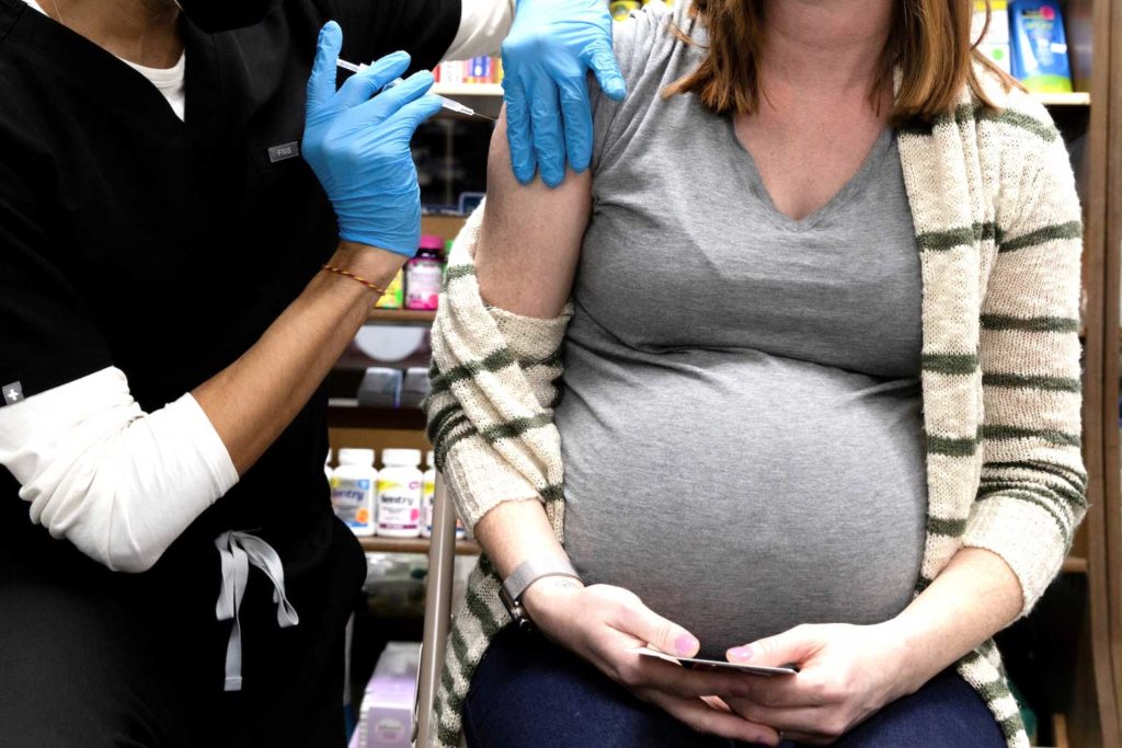 A pregnant woman receives a vaccine for the coronavirus disease (COVID-19) at Skippack Pharmacy in Schwenksville, Pennsylvania, U.S., February 11, 2021. REUTERS/Hannah Beier