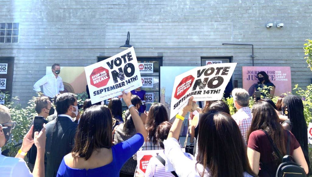 Supporters hold up “Vote No” signs before Newsom begins his remarks. | AJPress photo