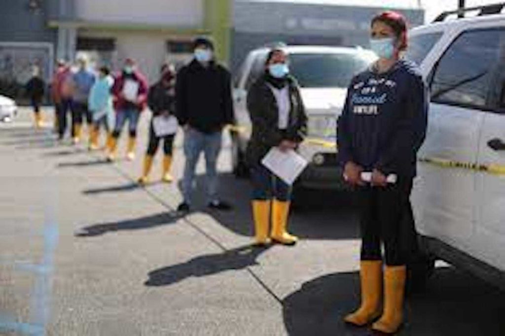 Food processing worker Carol DeLeon, 58, waits in line to receive a coronavirus disease (COVID-19) vaccination at a mobile vaccination drive for essential food processing workers at Rose & Shore, Inc., in Vernon, Los Angeles, California. REUTERS
