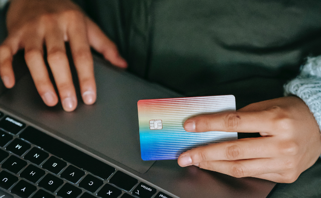 An individual using a credit card to make an online purchase, highlighting the convenience and ease of shopping with credit cards.