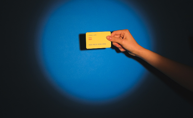A credit card is displayed on a spotlight.