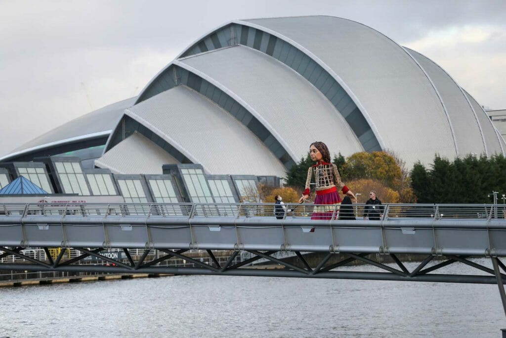  "Little Ama,l",a 3.5-metre-tall puppet of a young Syrian refugee girl, walks across a bridge during the UN Climate Change Conference (COP26) in Glasgow, Scotland, Britain, November 9, 2021. REUTERS/Russell Cheyne