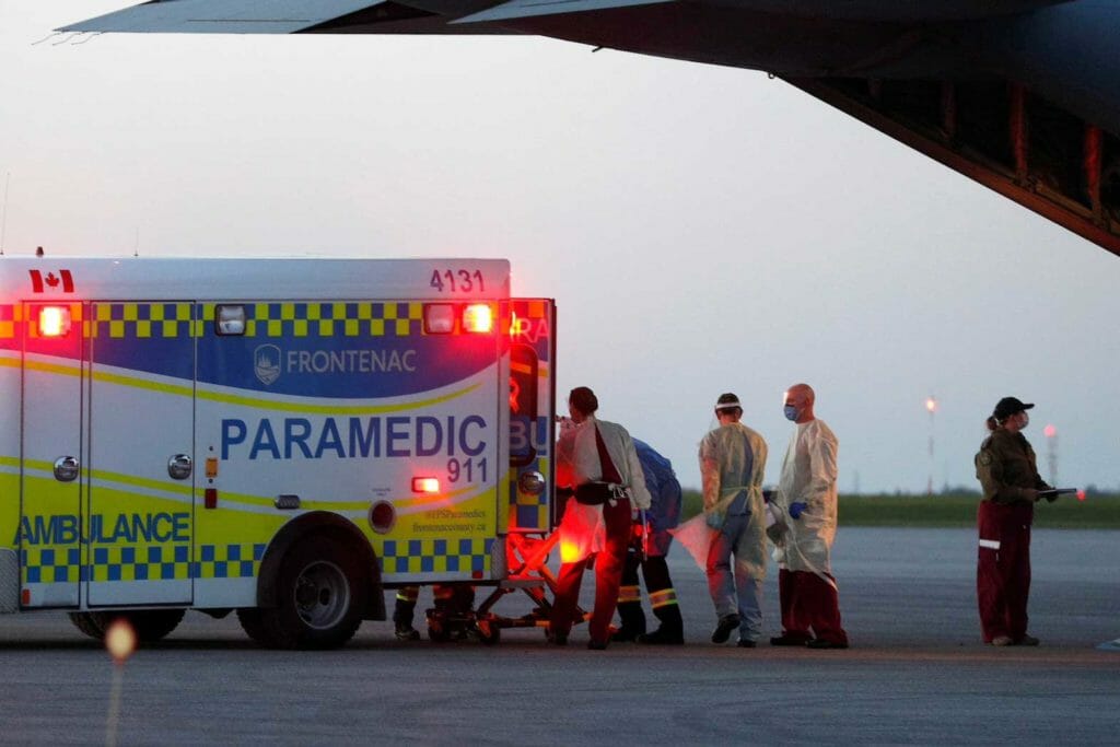 Medical personnel unload a patient from a Royal Canadian Air Force CC-130J Hercules transport aircraft which departed from Saskatoon, after the province of Saskatchewan said it would be sending patients with the coronavirus disease (COVID-19) from overloaded ICU wards to Ontario hospitals, in Kingston, Ontario, Canada October 28, 2021. REUTERS/Lars Hagberg