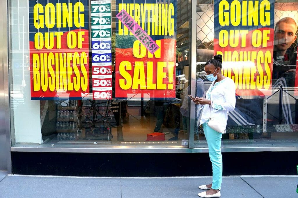 People walk past a business that is closing following the outbreak of the coronavirus disease (COVID-19) in the Manhattan borough of New York City, New York, U.S., August 17, 2020. REUTERS/Carlo Allegri