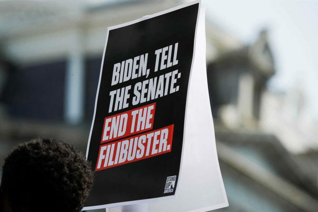 A sign is urging the Senate to "end the filibuster" and pass voting rights legislation is seen during a news conference near the White House in Washington, U.S., August 12, 2021. REUTERS/Gabrielle Crockett