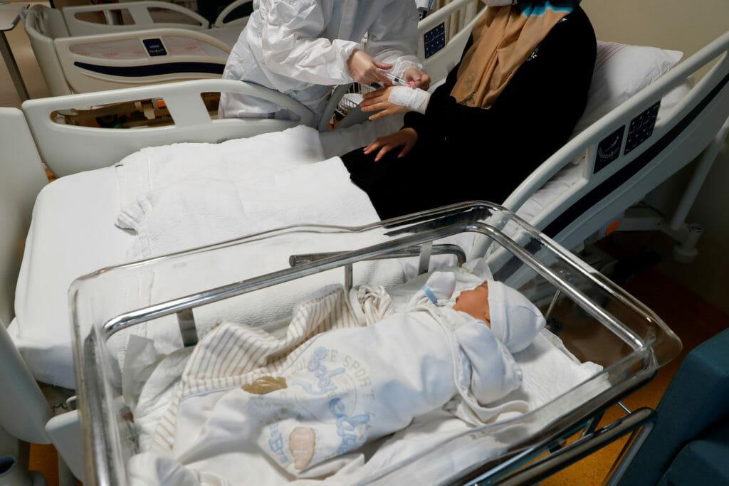  A member of the medical staff treats a coronavirus disease (COVID-19) positive woman next to her four-day old baby boy at the Basaksehir Cam and Sakura City Hospital in Istanbul, Turkey November 25, 2021. REUTERS/Murad Sezer