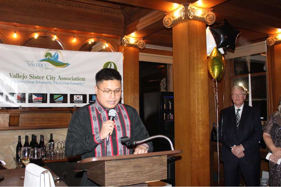   Vice Consul Adrian Audrey L. Baccay addresses attendees at the Vallejo-Baguio sister cities gala. Seen in the background is Vallejo Mayor Robert McConnell. CONTRIBUTED