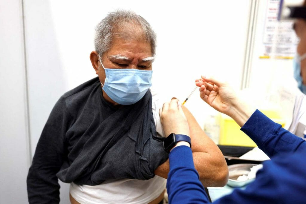 An elderly man receives a dose of Sinovac Biotech's CoronaVac COVID-19 vaccine, following the coronavirus disease (COVID-19) outbreak, at a community vaccination centre, in Hong Kong, China, February 25, 2022. REUTERS/Tyrone Siu
