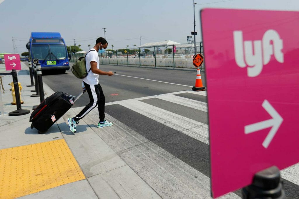  A traveler arriving at Los Angeles International Airport looks for ground transportation during a statewide day of action to demand that ride-hailing companies Uber and Lyft follow California law and grant drivers "basic employee rights'' in Los Angeles, California, U.S., August 20, 2020. REUTERS/Mike Blake