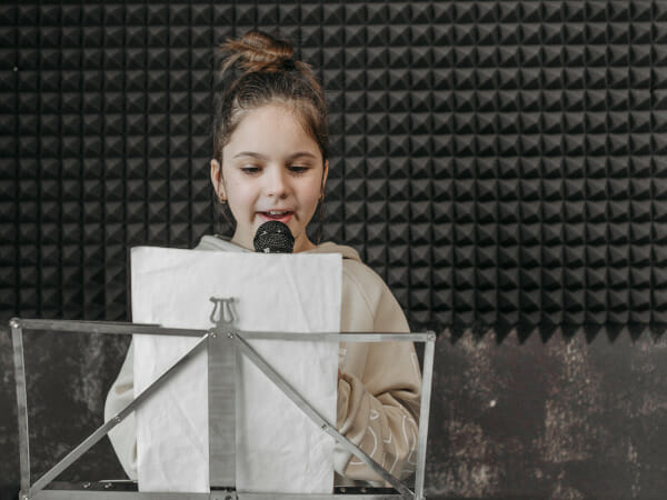 This is a girl recording a song at a recording studio.