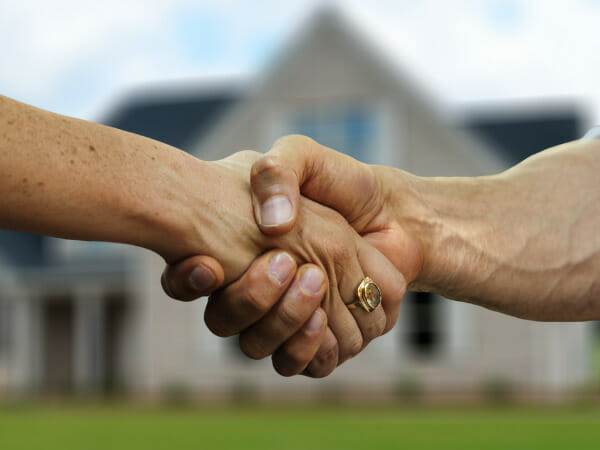 These are two people shaking hands after agreeing on the appraised value of a home.
