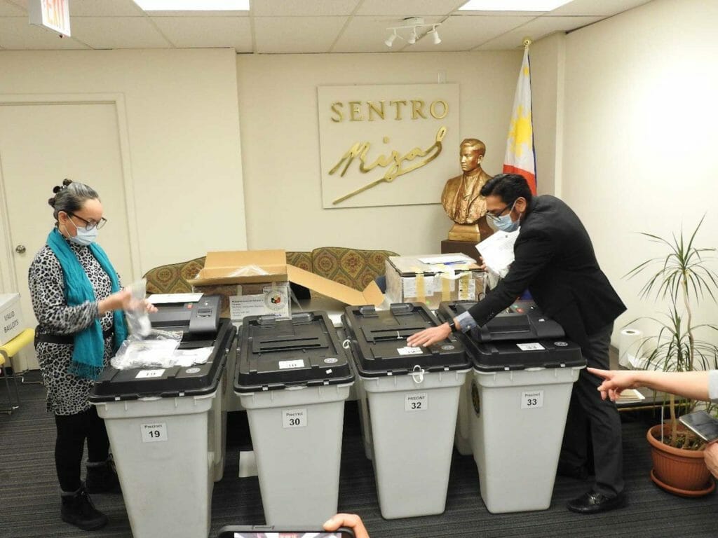 Toronto Consul Mary Grace Villamayor (left) and Consul Rodney Jonas L. Sumague (right), Chairpersons of the Consulate General’s two Special Board of Election Inspectors (SBEI) initialize the Vote Counting Machines (VCM). WEBSITE