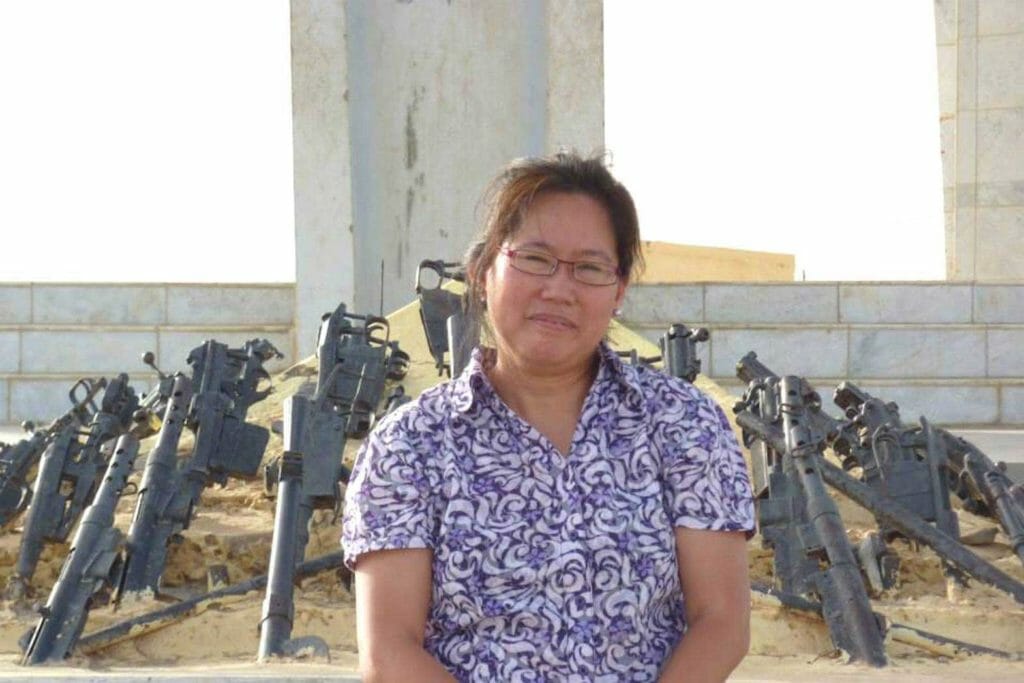Dr. Jade Pena in front of decommissioned weapons in Mali. CONTRIBUTED