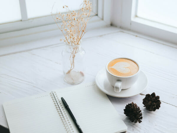 This is a cup of coffee and a notebook.